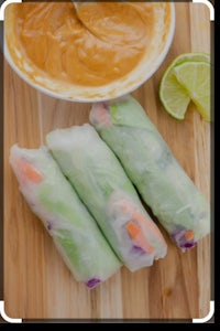 thai spring rolls with peanut sauce on a cutting board