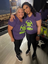 two women in purple shirts posing for a photo