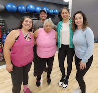 a group of people posing for a photo in a gym