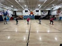 a group of people skateboarding in a gymnasium