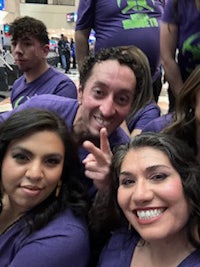 a group of people in purple shirts posing for a photo