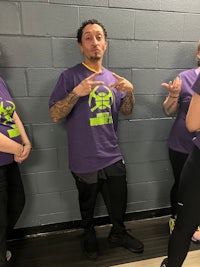 a group of people in purple shirts standing next to each other