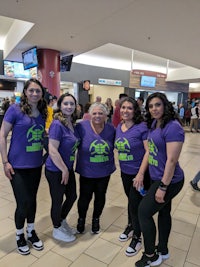 a group of women in purple t - shirts posing for a photo